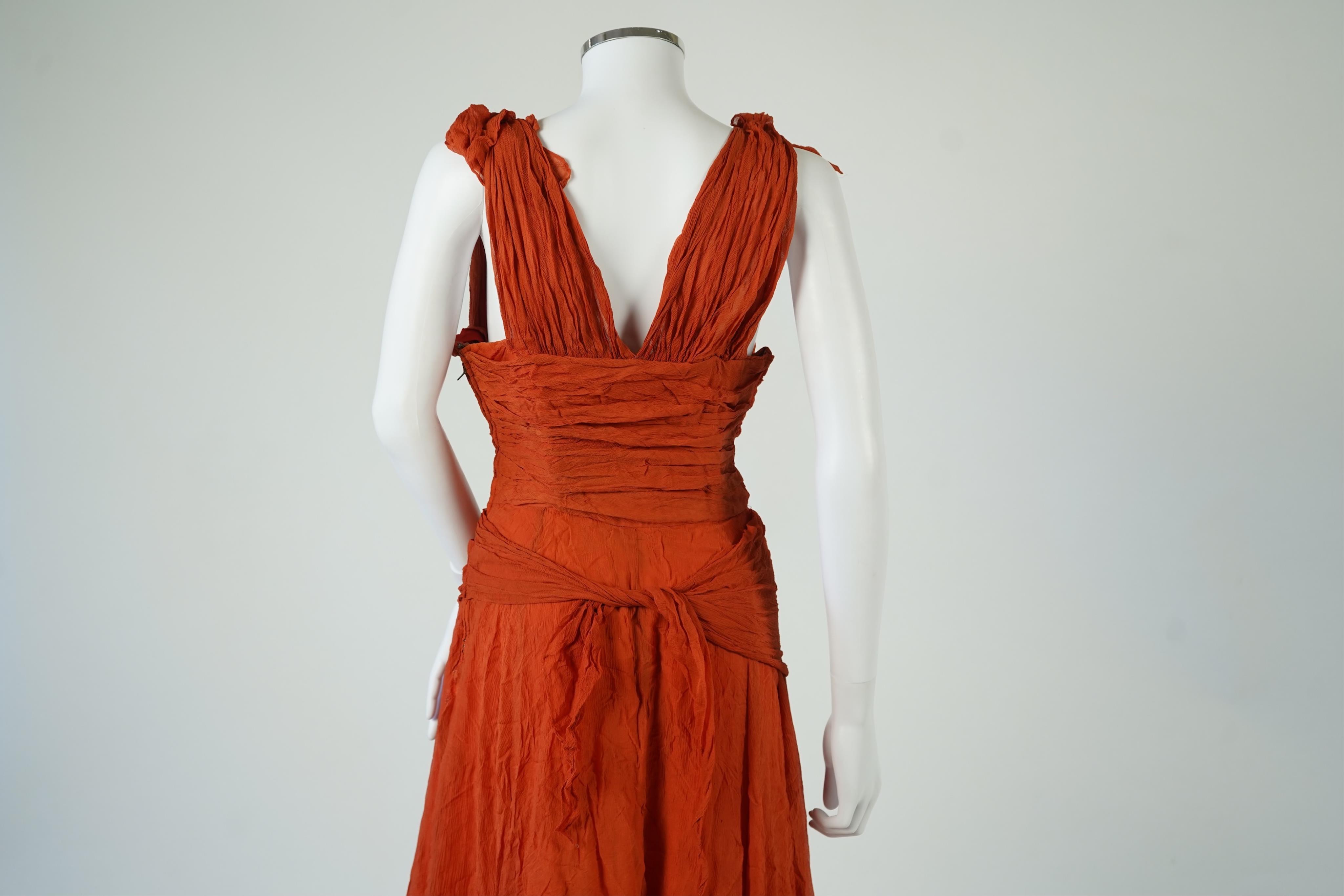 A 1940’s orange chiffon evening dress, with an orange silk taffeta lining, a pleated bodice and front apron panel tied at the back., 156 cm long. Condition - there are a few small holes in the chiffon at the back of the